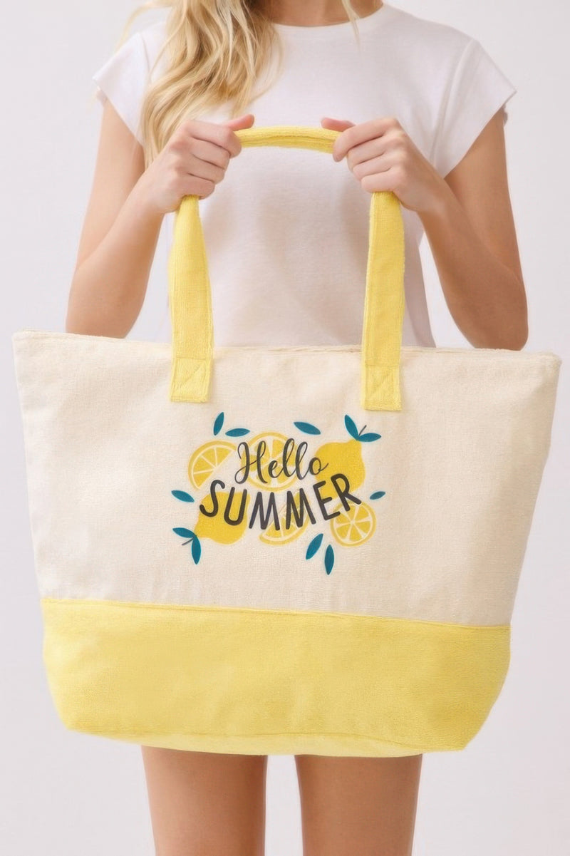 Close-up of a stylish individual holding the Beach Tote Bag in Yellow by HD ACCESSORIES, showcasing its bright design with lemon graphics, fitting for summer activities. A fresh addition among new arrivals.