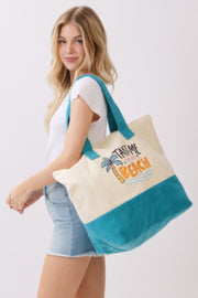 Model smiling with the Beach Tote Bag in Blue by HD ACCESSORIES, showcasing the vibrant design and spacious interior. The Beach Tote Bag in Blue is perfect for beach outings, embodying the carefree spirit of summer with its fun slogan 'Take Me To The Beach.' This tote bag combines style and functionality, making it a standout from the NEW ARRIVALS collection.