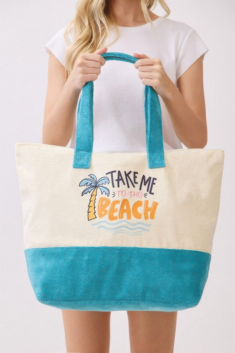 Model holding the Beach Tote Bag in Blue by HD ACCESSORIES, featuring the graphic 'Take Me To The Beach.' This stylish tote bag is perfect for bright summer days and beach trips, offering a spacious interior and casual vibe. Part of the NEW ARRIVALS collection, this Beach Tote Bag in Blue combines fashion and practicality for everyday use.