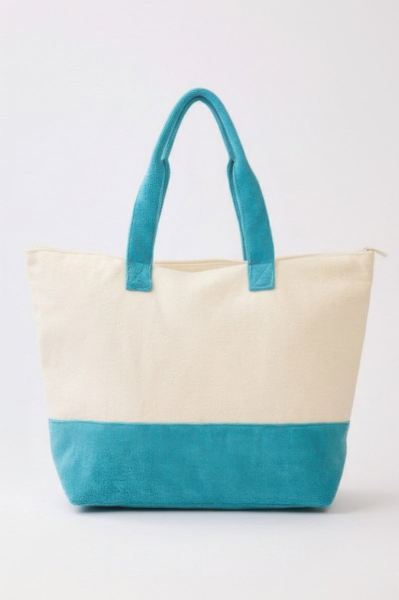The back view of the Beach Tote Bag in Blue by HD ACCESSORIES, showcasing a stylish blue bottom and a woven upper. This trendy Blue Tote Bag is perfect for beach days, offering practicality and a chic look. A must-have for those who love the slogan 'Take Me To The Beach,' this tote fits seamlessly into casual summer activities, making it a versatile addition to your collection. Explore more from the NEW ARRIVALS collection.