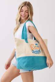 Close-up of a woman carrying the Beach Tote Bag in Blue - Life Is Better At The Beach from HD ACCESSORIES, showcasing the cheerful slogan and palm graphic. Great for summer outings, categorized as ACCESSORIES, Beach Tote Bag, Blue, CCPRODUCTS, HANDBAGS, NEW ARRIVALS, Tote Bag.