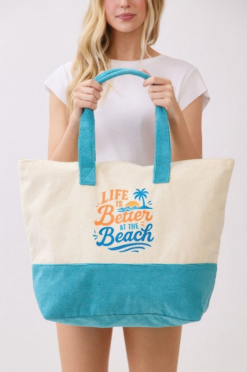 Model in a casual setting with the Beach Tote Bag in Blue - Life Is Better At The Beach from HD ACCESSORIES, highlighting its cozy terrycloth texture. Essential for beach outings, included in ACCESSORIES, Beach Tote Bag, Blue, CCPRODUCTS, HANDBAGS, NEW ARRIVALS, Tote Bag.