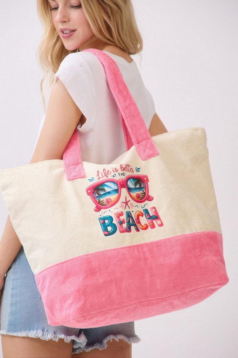 The Life Is Better At The Beach Tote Bag by HD ACCESSORIES is showcased as the model smiles while modeling it. This spacious and stylish bag is perfect for summer days and is a standout among accessories, handbag collections, and new arrivals.