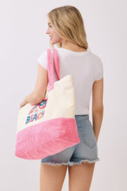 From behind, the model displays the Life Is Better At The Beach Tote Bag from HD ACCESSORIES. The beach-inspired graphics and roomy design provide a stylish option for those looking for functional accessories and trendy handbags in the new arrivals.