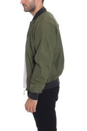 Side view of a model in an Olive Lightweight Windbreaker Jacket from Astral Signature™, ideal for layering. Features sleek design and practical elements. Keywords: Windbreaker Jacket, Black, Burgundy, CCPRODUCTS, Grey, MENS, MENS OUTERWEAR, MENS TOPS, NEW ARRIVALS.