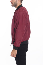 Model presenting a side view of a Burgundy Lightweight Windbreaker Jacket from Astral Signature™, combining elegance and functionality. Keywords: Windbreaker Jacket, Black, Burgundy, CCPRODUCTS, Grey, MENS, MENS OUTERWEAR, MENS TOPS, NEW ARRIVALS.