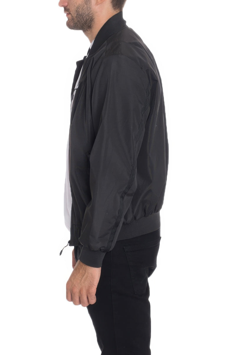 Side view of a model wearing a Black Lightweight Windbreaker Jacket by Astral Signature™, emphasizing its sleek design and comfort. Keywords: Windbreaker Jacket, Black, Burgundy, CCPRODUCTS, Grey, MENS, MENS OUTERWEAR, MENS TOPS, NEW ARRIVALS.