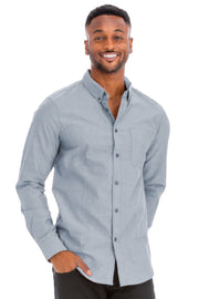 A man smiling while wearing a light blue long sleeve shirt from Astral Signature™, perfect for casual outings. This Long Sleeve Shirt features a breathable material blend for comfort and classic button-down styling. Part of the latest collection including CCPRODUCTS, Charcoal, H.Navy, MENS, MENS TOPS, and NEW ARRIVALS.