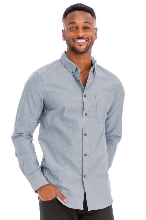 A man smiling while wearing a light blue long sleeve shirt from Astral Signature™, perfect for casual outings. This Long Sleeve Shirt features a breathable material blend for comfort and classic button-down styling. Part of the latest collection including CCPRODUCTS, Charcoal, H.Navy, MENS, MENS TOPS, and NEW ARRIVALS.