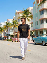 Astral Inner Peace Minimalist Tee — Gold ‘PEACE’ Script Men’s T-Shirt model walking on a sunny street, showcasing this stylish men’s fashion item. Perfect gift for him, this men’s heavyweight tee combines comfort and contemporary design.