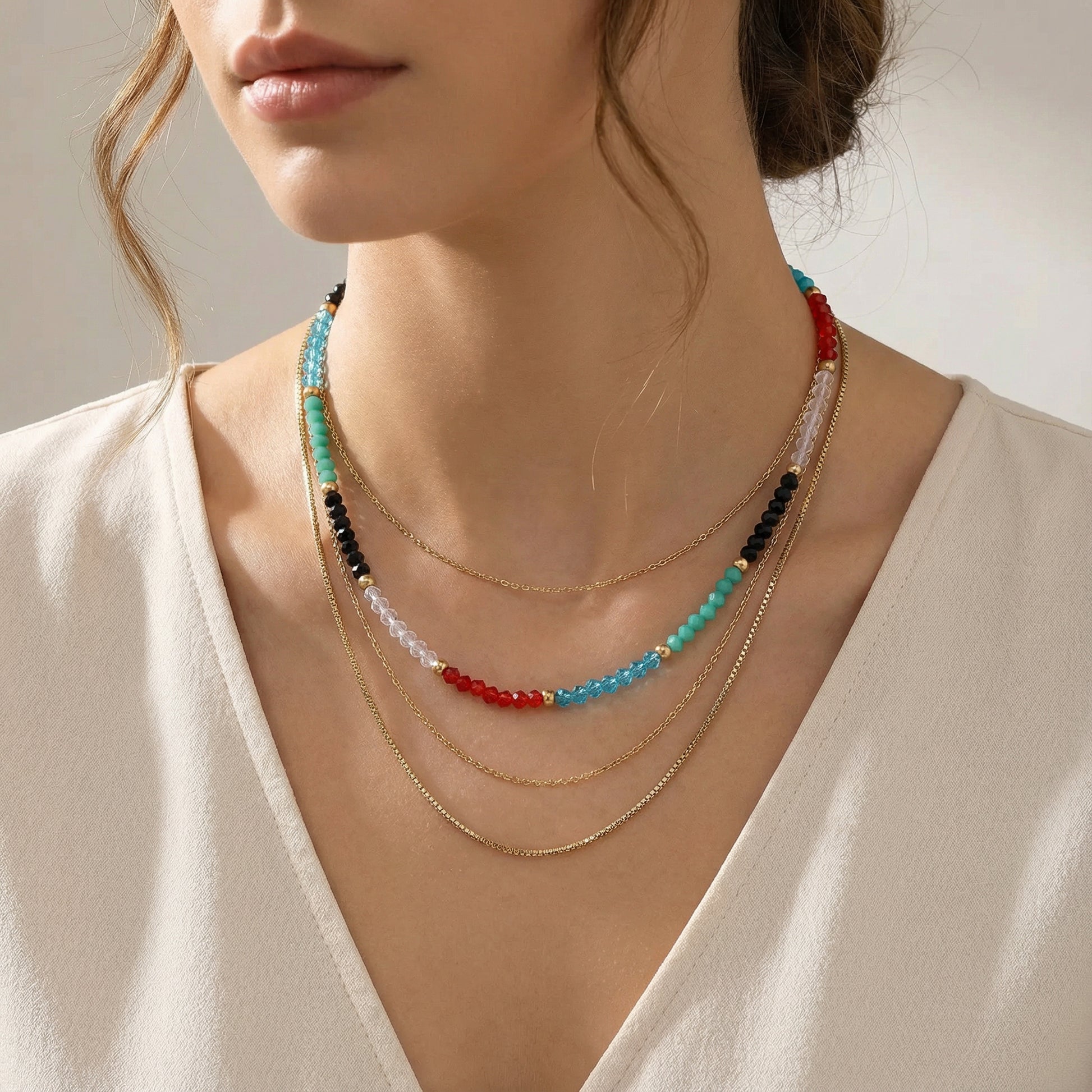 A close-up of a model wearing the Rainbow Aura Layers necklace by Astral Signature, featuring 14K Gold Plated Stainless Steel and clear quartz beads, perfect for everyday wear. This stylish piece from Astral Signature is an ideal gift for her and is part of a limited edition collection, showcasing the vibrant colors of the Rainbow Aura Layers.