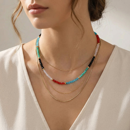 A close-up of a model wearing the Rainbow Aura Layers necklace by Astral Signature, featuring 14K Gold Plated Stainless Steel and clear quartz beads, perfect for everyday wear. This stylish piece from Astral Signature is an ideal gift for her and is part of a limited edition collection, showcasing the vibrant colors of the Rainbow Aura Layers.