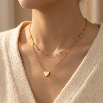 Close-up of the Layered Heart Necklace - 18K Gold Plated Stainless Steel by Astral Signature displayed on a model, highlighting its beautiful layering and timeless design. Perfect for everyday wear and a thoughtful gift for her. Limited edition item by Astral Design.