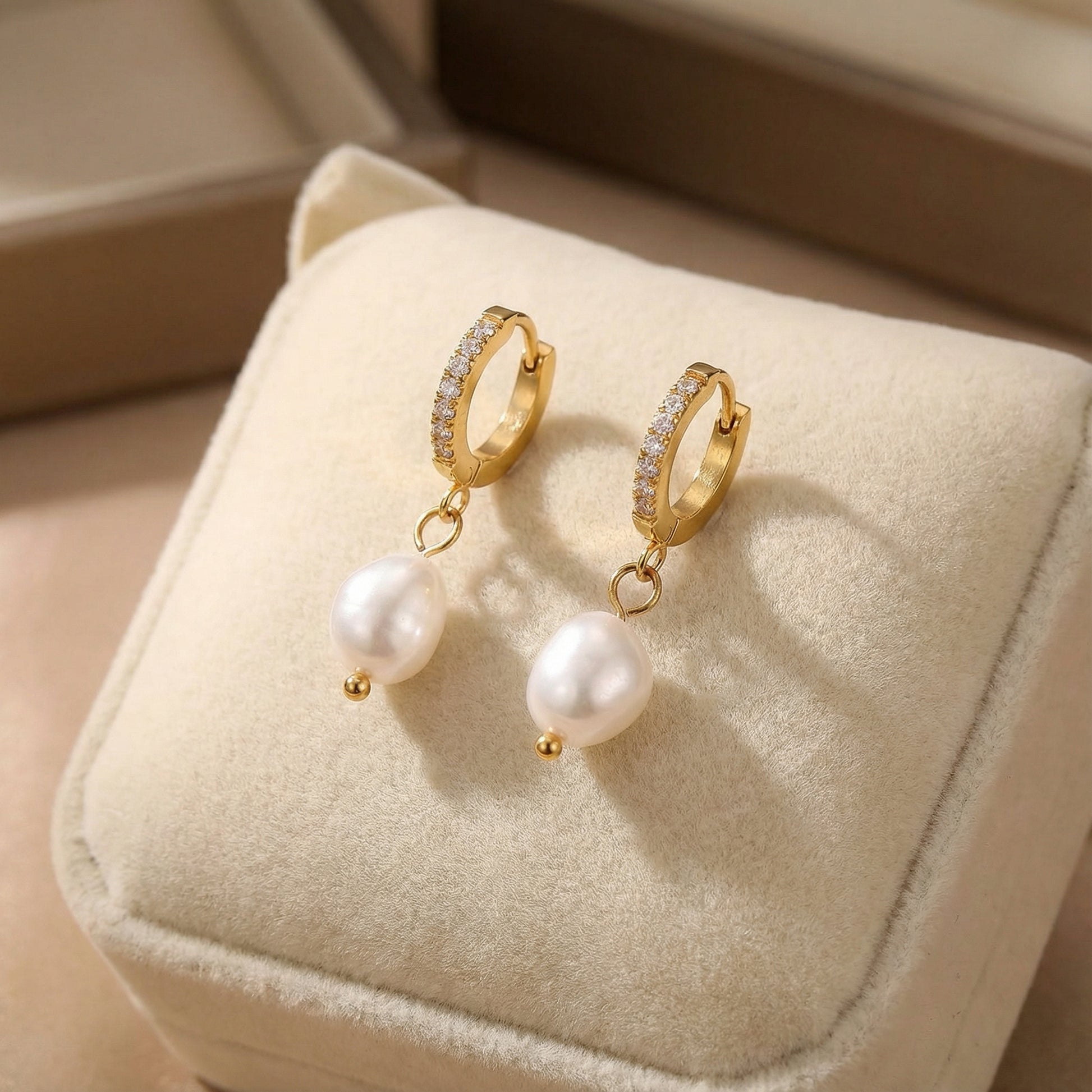 Pearl Drop Hoops - Freshwater Pearl - 18K Gold Plated Stainless Steel by Astral Signature displayed on a soft cushion, emphasizing their refined beauty. This jewelry is a fantastic everyday wear piece and an excellent gift for her, reflecting the stylish Astral Design in limited edition.