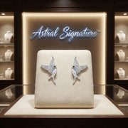 The Celestial Hummingbird Earrings displayed beautifully on a presentation set in an Astral Signature jewelry showcase. These white gold plated eco-brass earrings, adorned with zirconia, are a perfect gift for her, elegantly combining style and comfort with S925 sterling silver posts.