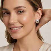 A model wearing the beautiful Shell Goddess Earrings featuring a sculptural shell design, made by Astral Signature™. Ideal as a gift for her, these earrings combine sterling silver (S925) with white gold plated eco-brass and zirconia for a dazzling look.