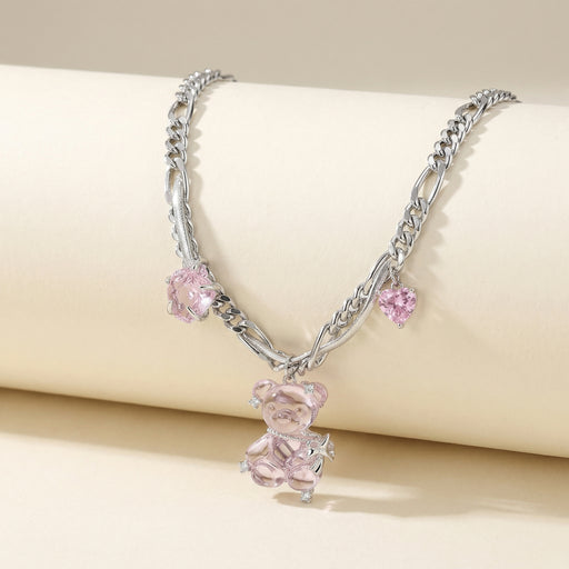 Close-up view of the Blush Dreams Chain by Astral Signature showcasing a playful bear pendant made from white gold plated eco-brass, adorned with pink zirconia. This necklace features a leather cord and highlights the intricate design of eco-friendly materials.