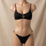 A mannequin displaying the Golden Chainlink Accent Black Ribbed Bikini from Stylish Swimwear, showcasing its elegant design and ribbed texture. This women's bikini is perfect for beach vacations and stylish summer outfits.