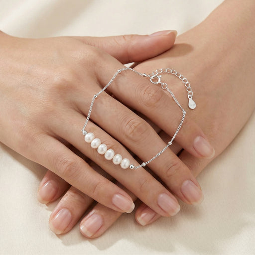 Close-up of hands displaying the Pearl Whisper Bracelet from Astral Signature, highlighting the baroque pearls on a delicate chain. This stylish accessory is ideal for everyday wear and makes a thoughtful gift for friends or her, showcasing the exquisite craftsmanship of Astral Design in this limited edition.