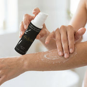 Application of Brightening Face & Body Exfoliator with Kojic Acid by Astral Signature on skin. This exfoliator is formulated with Kojic Acid, Shea Butter, and Vitamin C to ensure a brighter and smoother skin texture, targeting dark spots effectively.