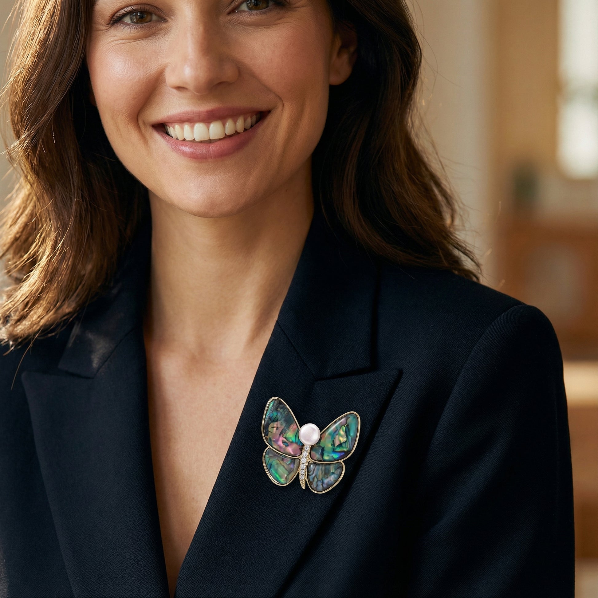 Woman wearing the Rainbow Butterfly Brooch Pin by Astral Signature on a black blazer. This elegant pin showcases 14K Gold Plated Eco-Brass and a decorative freshwater pearl. Ideal Jewelry Pins, Pins for stylish outfits.