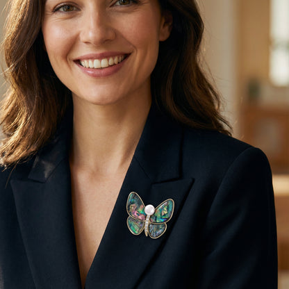 Woman wearing the Rainbow Butterfly Brooch Pin by Astral Signature on a black blazer. This elegant pin showcases 14K Gold Plated Eco-Brass and a decorative freshwater pearl. Ideal Jewelry Pins, Pins for stylish outfits.