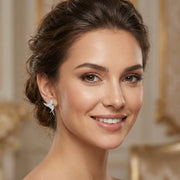 A model wearing the Celestial Hummingbird Earrings, highlighting the radiant look of these white gold plated eco-brass earrings. Designed by Astral Signature, they sparkle with zirconia and provide a stunning accessory choice, making them perfect as a gift for her.
