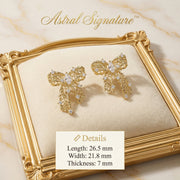 The Ribbon Dreams Bow Earrings by Astral Signature presented in a detailed shot, showcasing the 18K Gold Plated Eco-Brass material and sparkling zirconia. These elegant earrings are perfect Eco-Brass Earrings and a delightful Gift for Her, featuring hypoallergenic Sterling Silver (S925) posts.