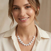 Happy woman adorned with the Lunar Pearl Arc Necklace - Sterling Silver by Astral Signature, radiating sophistication. An exquisite gift for her, this piece is crafted with Astral Design flair and is a limited edition item.