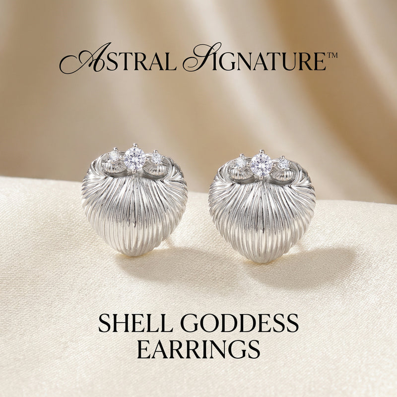 Elegant Shell Goddess Earrings placed on a satin background, featuring the intricate design and zirconia sparkle from Astral Signature™. These earrings make the perfect gift for her, combining white gold plated eco-brass with the quality of sterling silver (S925).