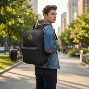 Young man wearing the Astral Signature Prestige Backpack in black with gold AS monogram while walking down a city street, showcasing this stylish accessory for daily wear.