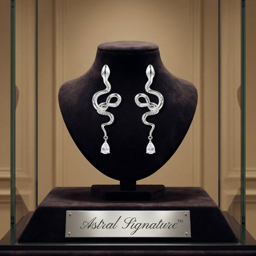 Serpentine Crystal Drops displayed in an elegant case by Astral Signature, showcasing exquisite drops and earrings made from Eco-Brass. These White Gold Plated Eco-Brass earrings are adorned with zirconia and Sterling Silver (S925) elements.