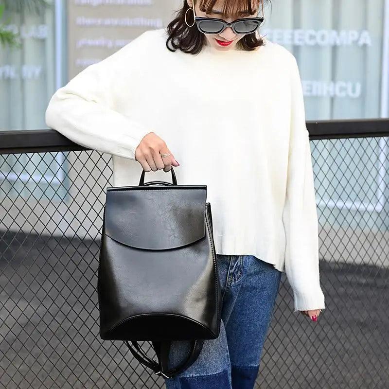 A model wearing a white sweater and jeans, showcasing the Urban Guard Backpack by Stevvex, featuring a sleek design perfect for daily use. Shop now at Shopify Collective.