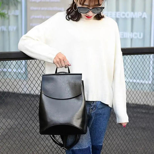A model wearing a white sweater and jeans, showcasing the Urban Guard Backpack by Stevvex, featuring a sleek design perfect for daily use. Shop now at Shopify Collective.