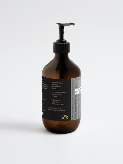 The back view of Astral Signature Hand & Body Wash, Ginger & Smoky Cardamom highlighting its natural certified formula, suitable for all skin types. This gentle body wash features hydrating betaine, is vegan, gluten-free, and allergen label free, crafted in an amber packaging that signifies organic ingredients for daily use.